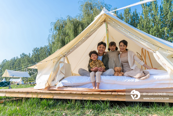 露营地帐篷下快乐的一家人