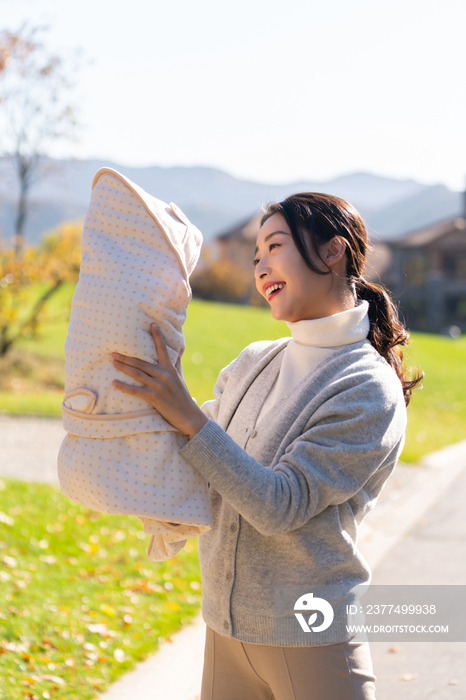 年轻的母亲抱着婴儿散步