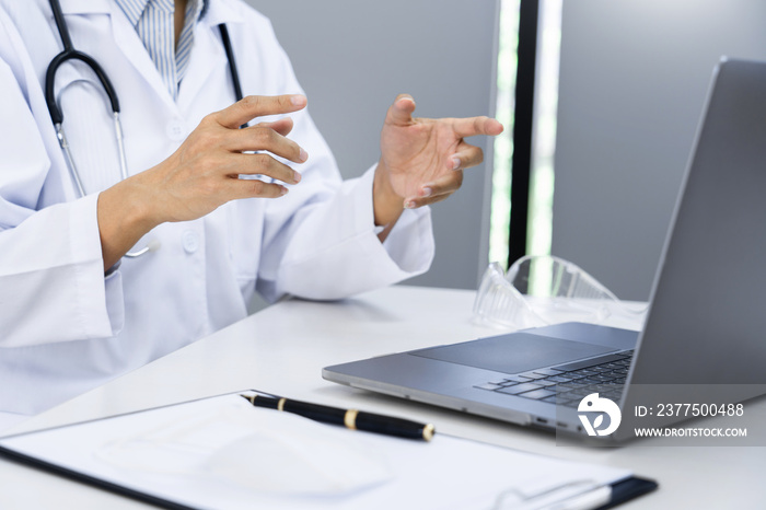 Asian women doctor using her laptop video call to explain medical consultation talking online with p