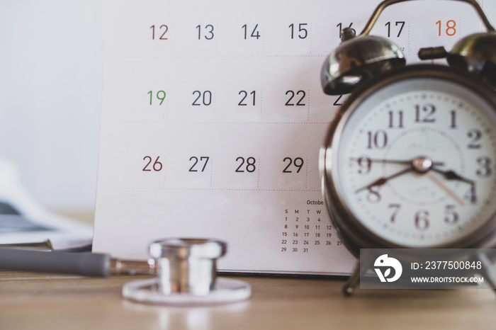 doctor office with calendar , alarm clock and stethoscope on desk