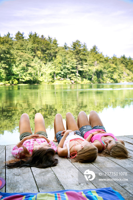 Female friends lying on jetty