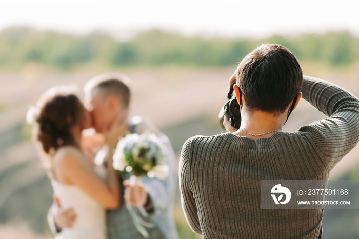 婚礼摄影师在秋天的大自然中拍摄新娘和新郎的照片，摄影师在