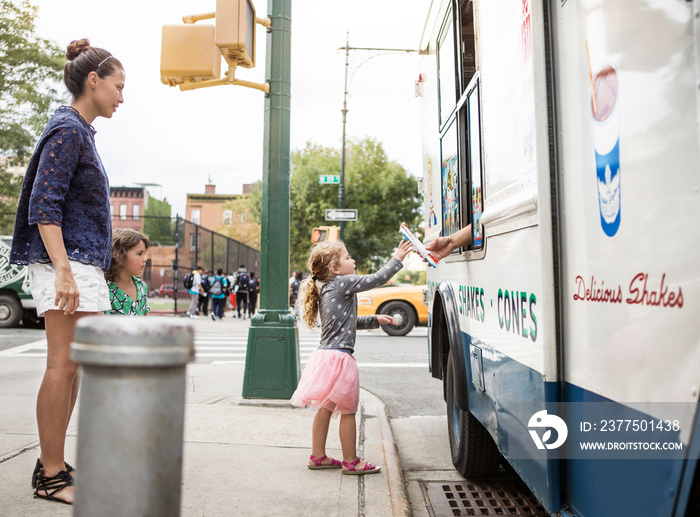 Mom and daughters (2-3, 4-5) getting ice creams