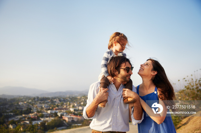 Parents with little daughter walking on hill