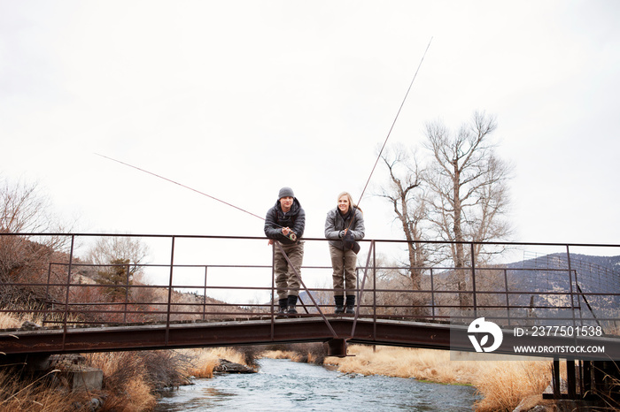 Couple fishing off bridge together