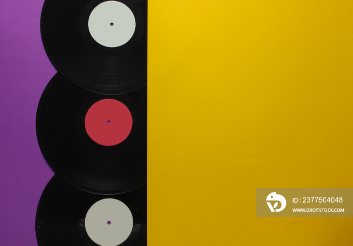 Halves of vinyl records on a purple yellow background. Retro Music Albums, 70s. Top view