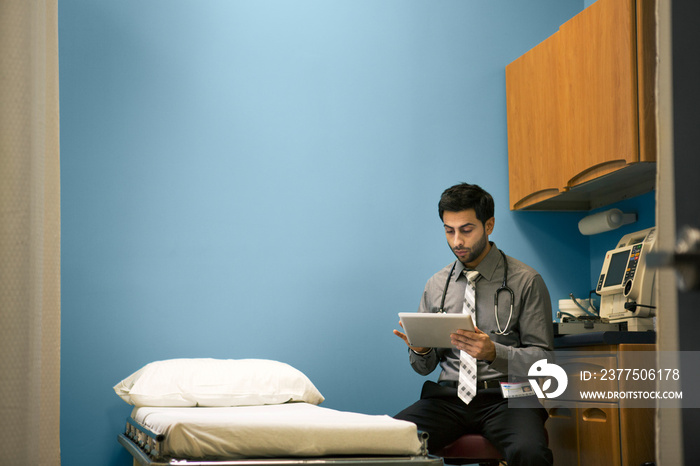 Doctor reading medical documents in hospital room