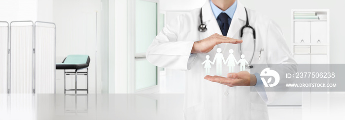 medical insurance concept, doctors hands protect a family icon with the clinic in the background, c