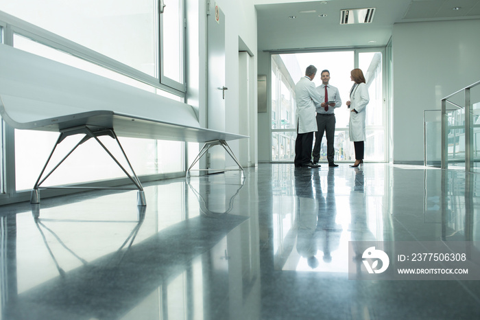 Doctors and administrator talking in hospital corridor