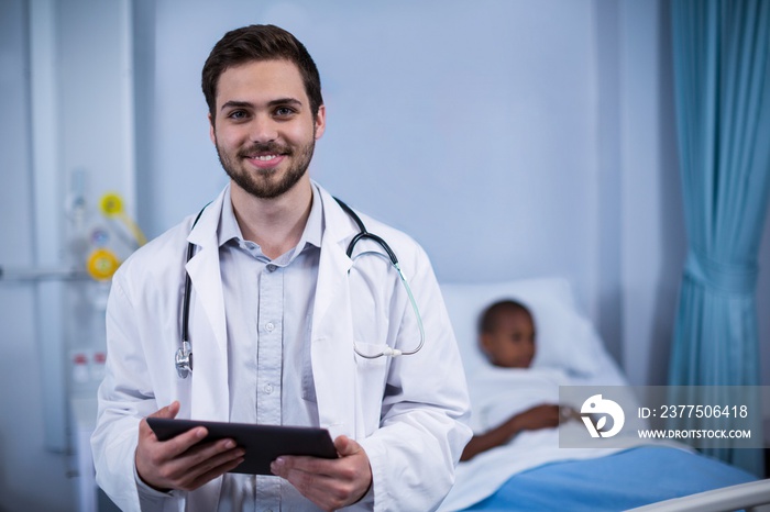 Portrait of smiling doctor standing with digital tablet