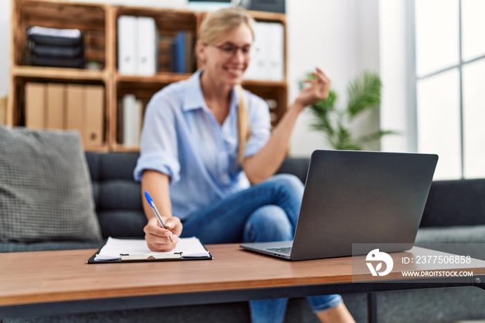 Young blonde woman having psychology online session at clinic