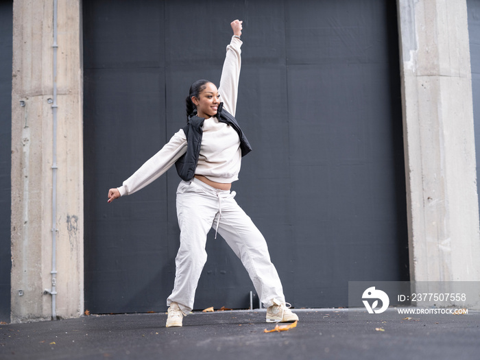 Teenage girl in sports clothing dancing in city