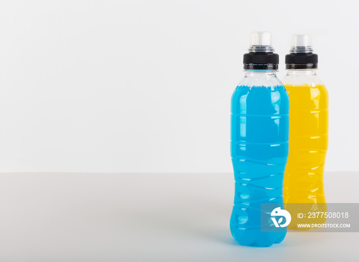 等渗能量饮料。蓝色和黄色透明液体瓶，白色ba上的运动饮料