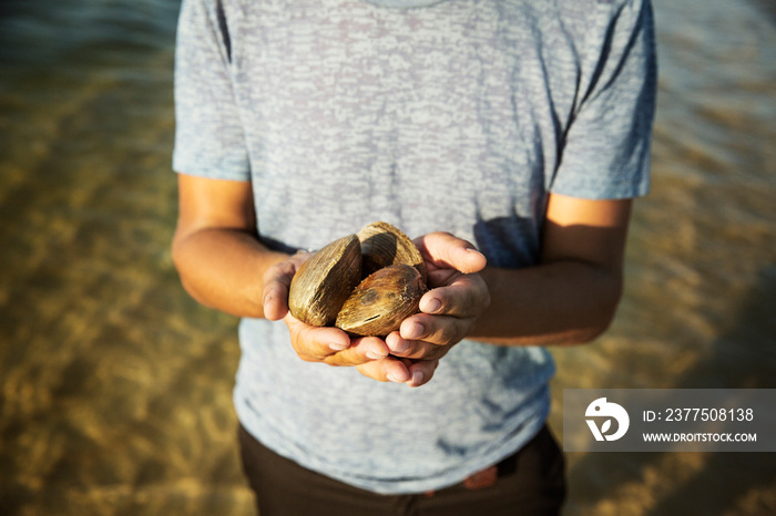 Man holding clams in hands