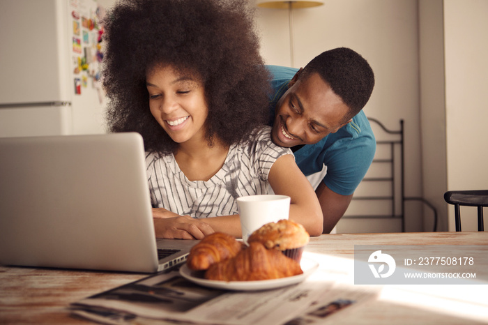 Couple using laptop at home