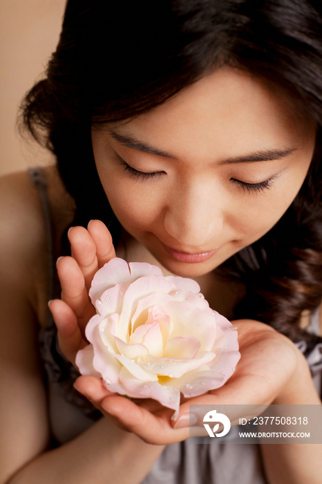 Young woman smelling flower, close up