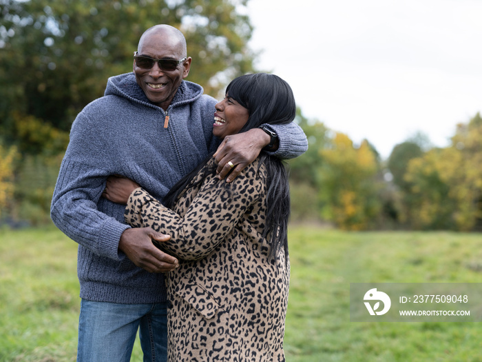 Senior couple laughing and embracing in nature