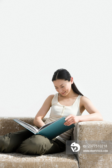 Woman reading a book on sofa