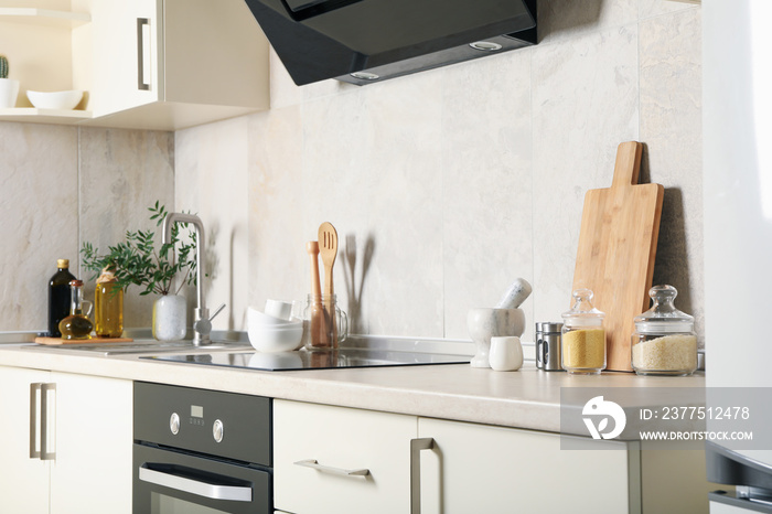 Modern kitchen interior with different supplies in light colors