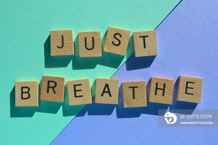 Just Breathe, phrase in wooden alphabet letters isolated on colourful background