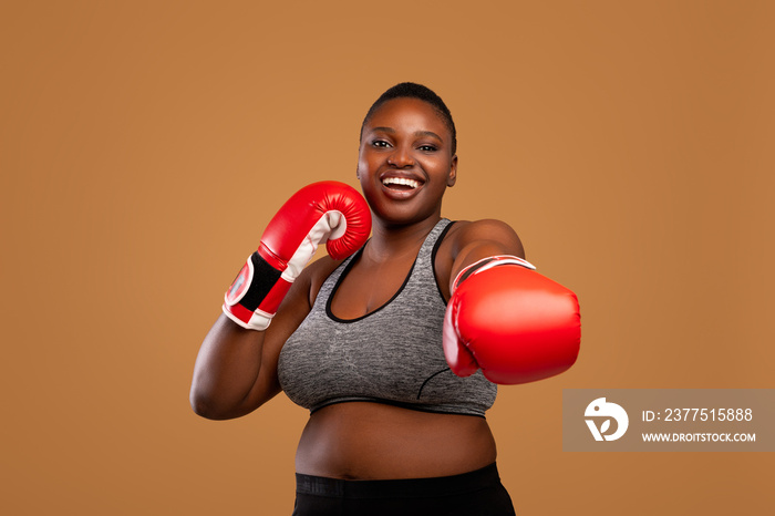 Young Black Woman Posing With Boxing Gloves At Studio