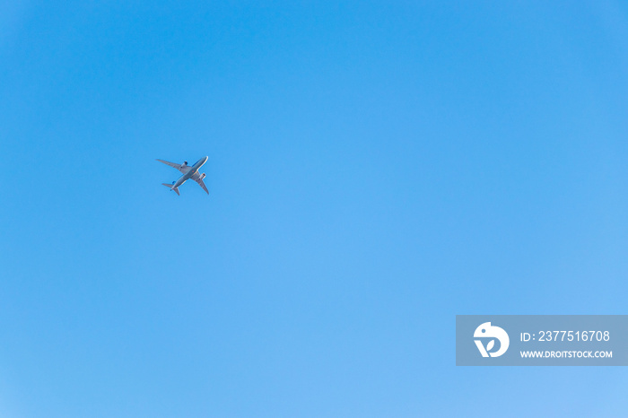 真っ青な空を飛ぶ白い飛行機