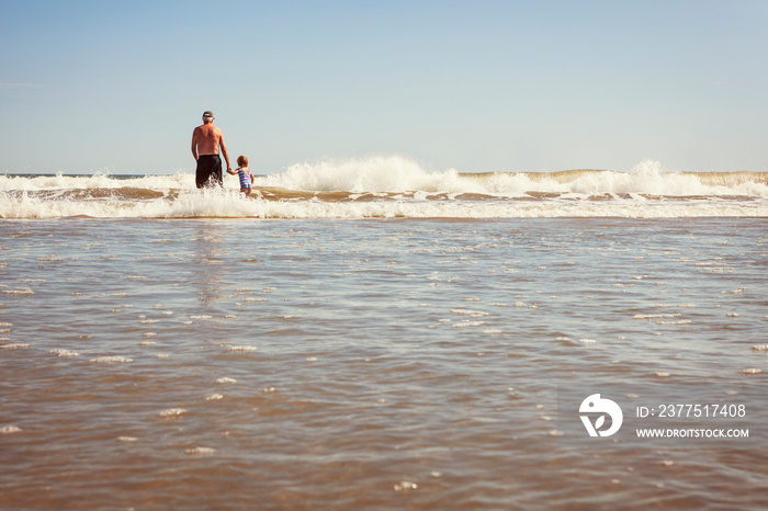 Grandfather and granddaughter (4-5) in sea