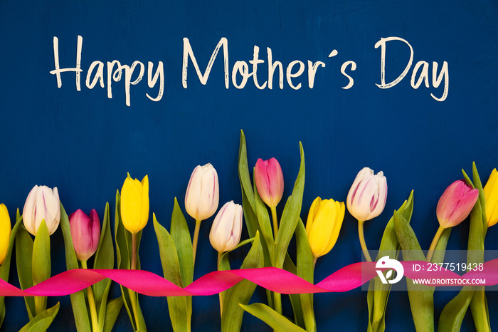 母亲节快乐。白色和粉色郁金香带丝带的春天花朵。蓝色木制背景