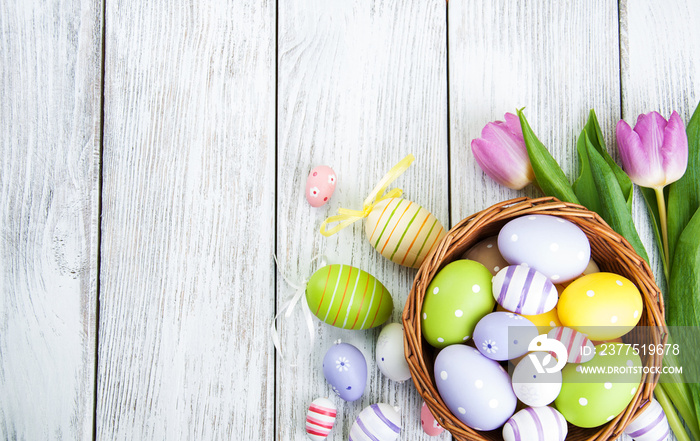 basket with easter eggs and tulips