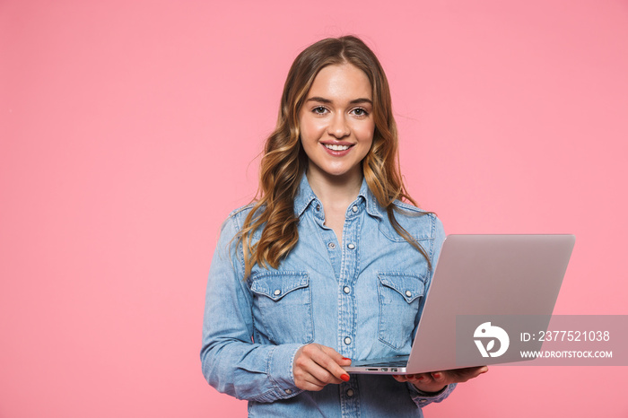 Smiling blonde woman wearing in denim shirt holding laptop computer