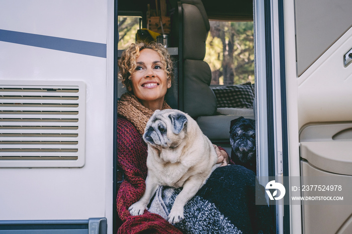 快乐的年轻成年女性微笑着，享受最好的朋友狗坐在露营车门上看着