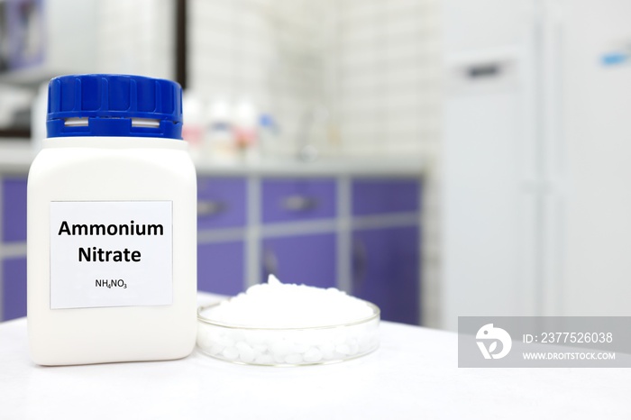 Selective focus of a bottle of Ammonium Nitrate in a plastic bottle beside a petri dish with white p