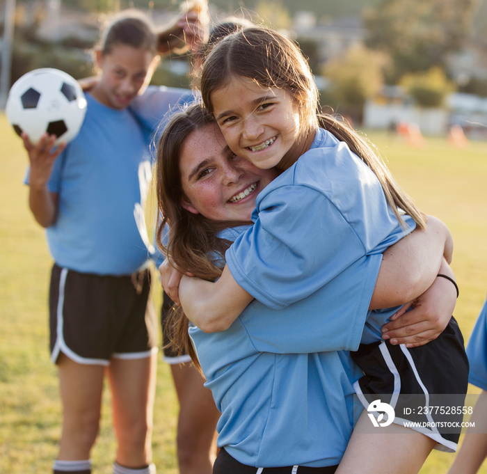 Happy girls playing on soccer field