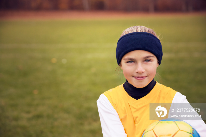 Portrait of girl (8-9) with soccer ball