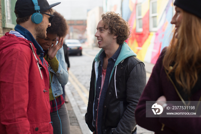 Young friends talking on city street