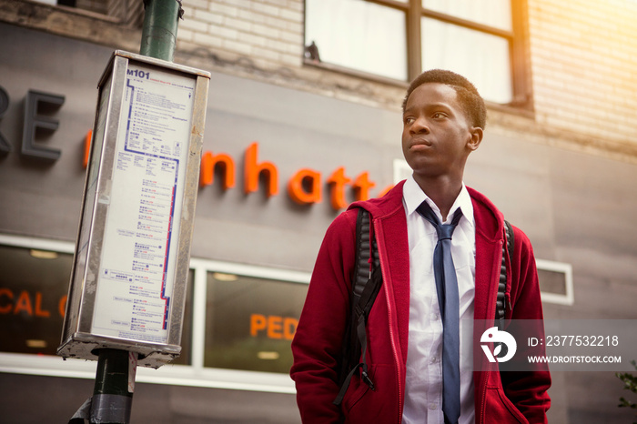 Teenage boy waiting at bus stop