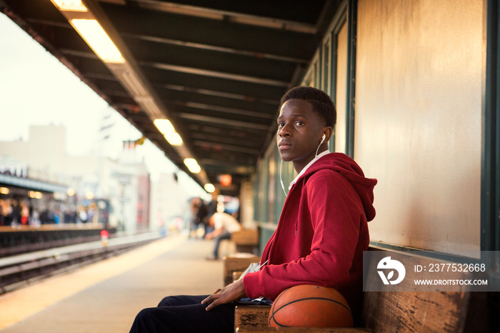 Boy sitting on bench at platform