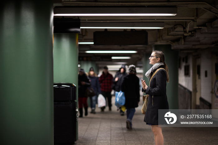 Side view of young woman standing at subway station