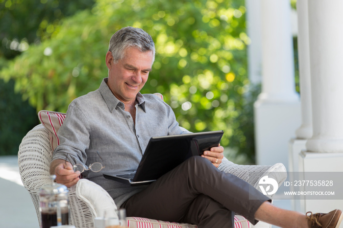 Senior man using laptop on patio