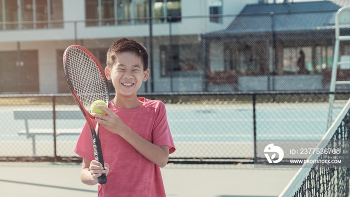 年轻、健康、快乐的青少年青少年混合亚洲男子网球初学者在户外蓝色球场上，