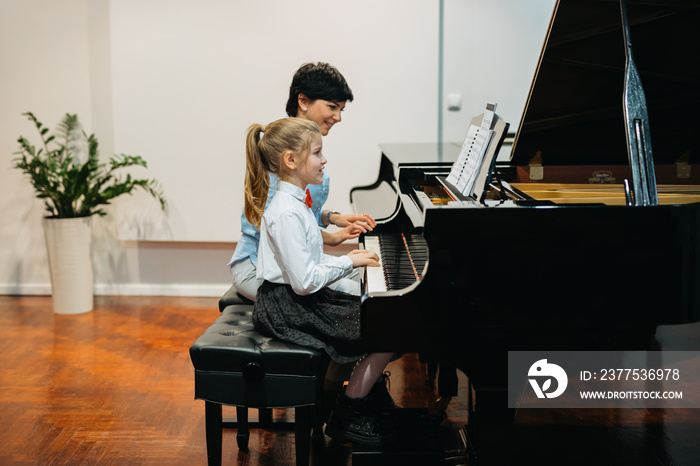 playing piano with teachers help