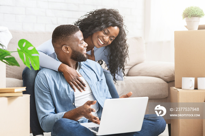 Emotional married couple checking interior ideas for new apartment online