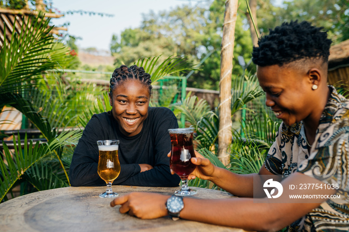 Two queer masculine women having a beer