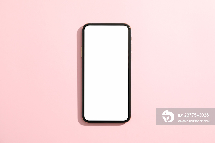 Phone with empty screen on pink background, top view