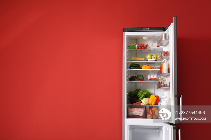 在彩色墙附近打开装满食物的冰箱
