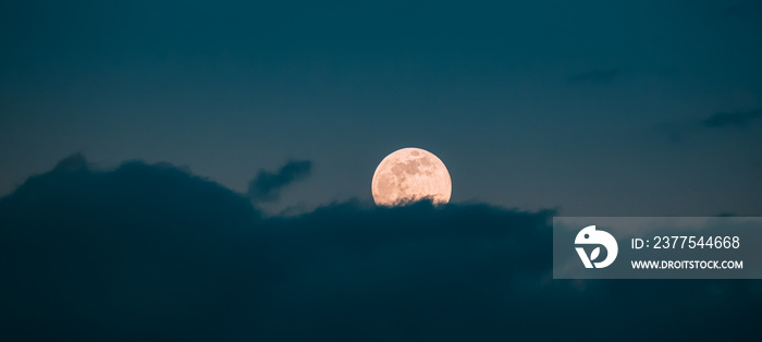 Full Moon Rising In Cloudy Evening Sky