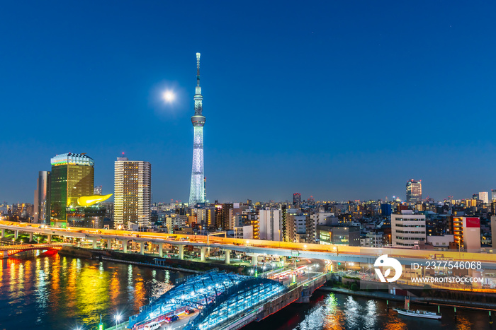 Tokyo Skytree and Sumida river at night with full moon in Asakusa district, Tokyo city, Japan.