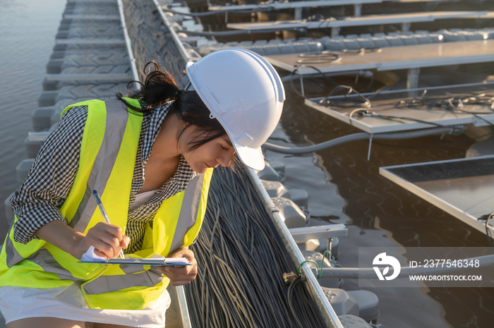 Asian engineer working at Floating solar farm,Renewable energy,Technician and investor solar panels 