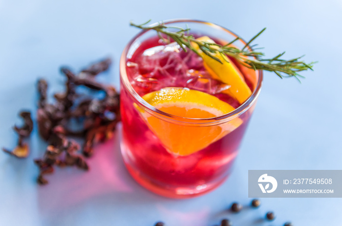 Beautiful hibiscus kombucha cocktail with gin and vodka, decorated with rosemary branch.