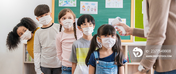 Portrait of students in medical mask, covid-19 outbreak. Teacher and kids with thermometer at presch